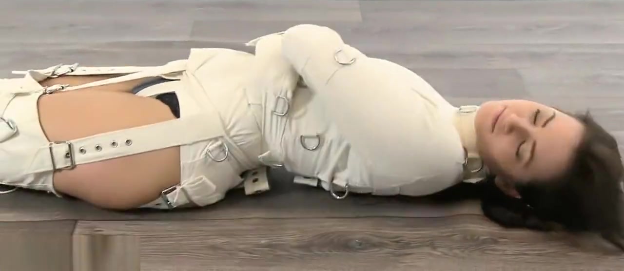 Girl trapped in straitjacket, bound legs.
