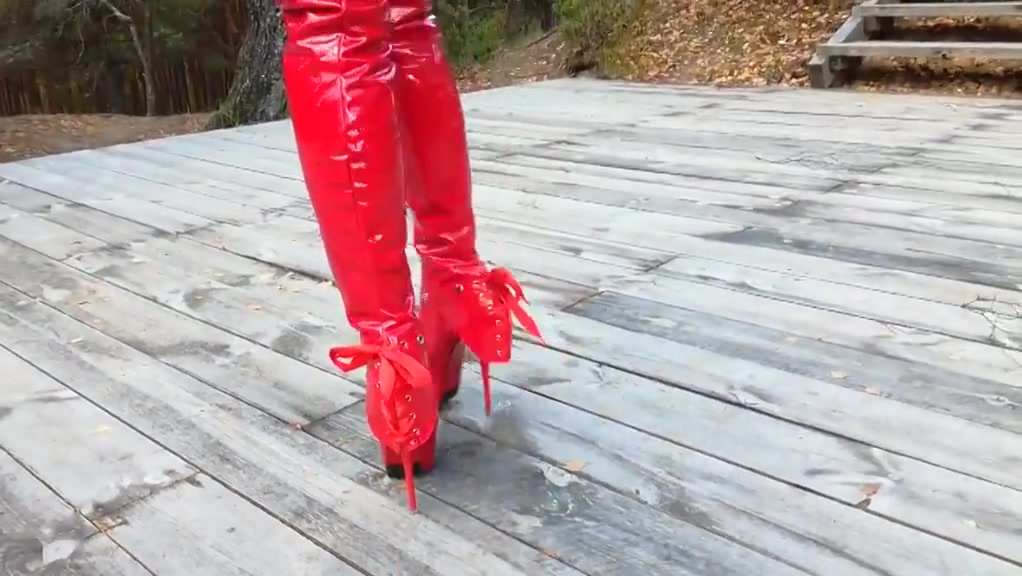 Lady L walking with red extreme sexy boots.
