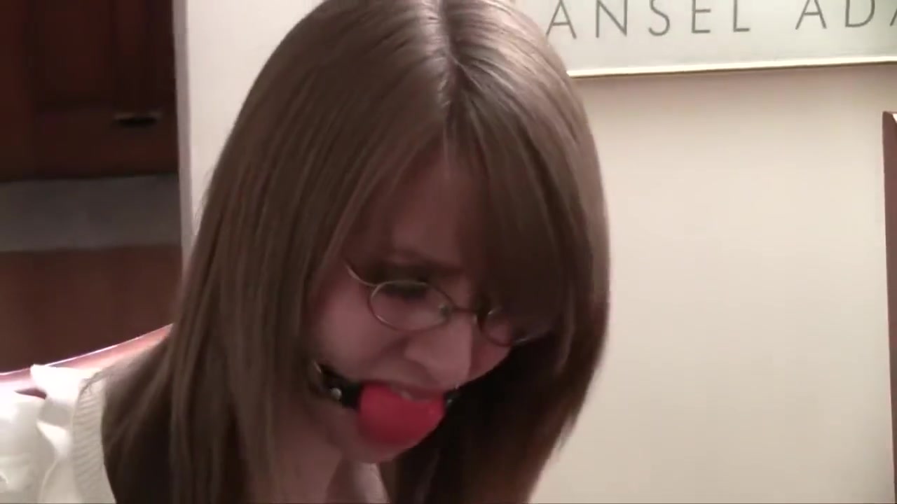 Secretary with glasses bound to a chair and ballgagged
